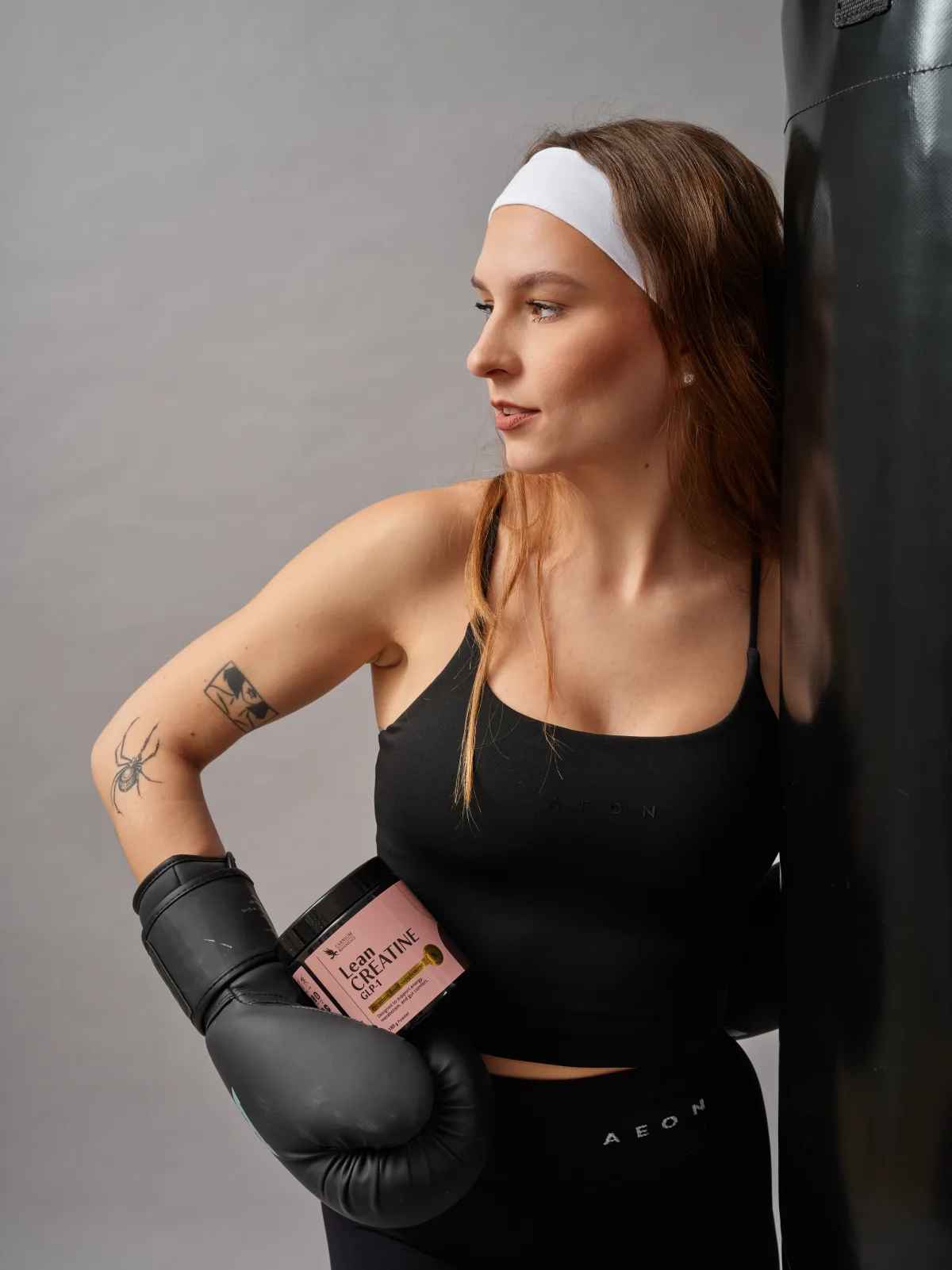 Nő bokszkesztyűvel, Lean Creatine-nel a zsák mellett